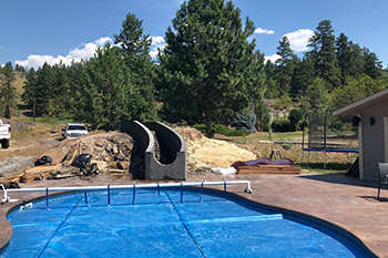 Pool with slide stamped concrete